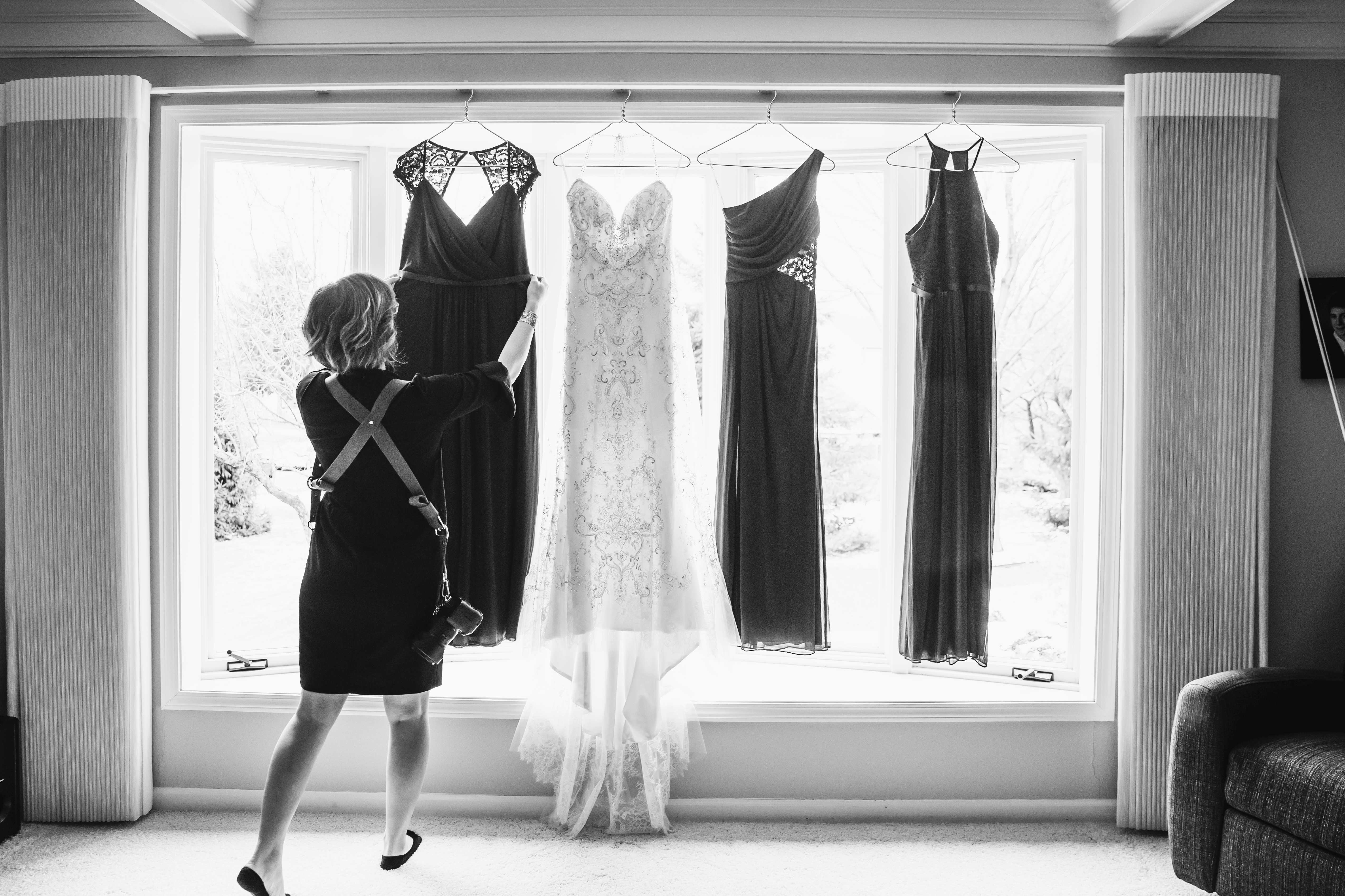 photographer hanging up wedding dresses