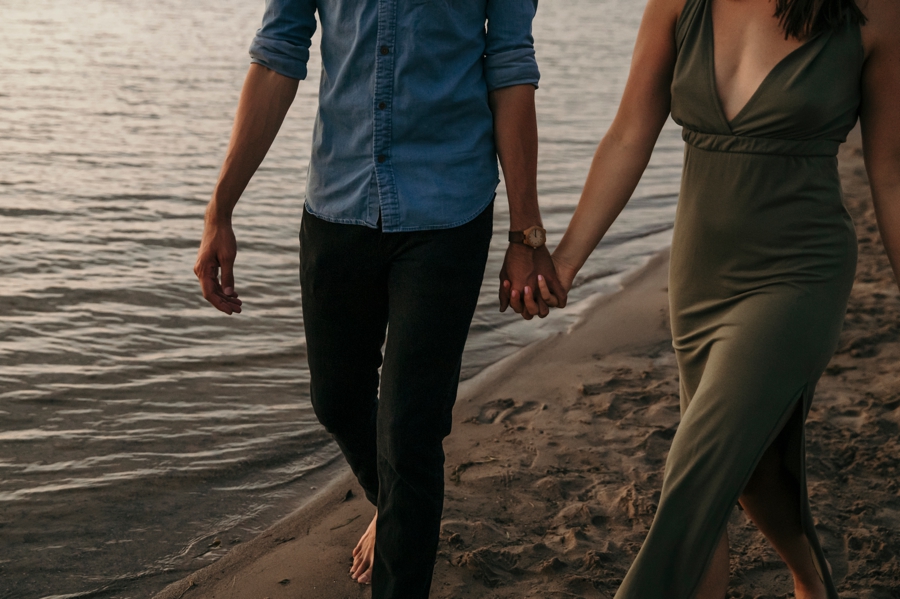 couple holding hands walking the beach