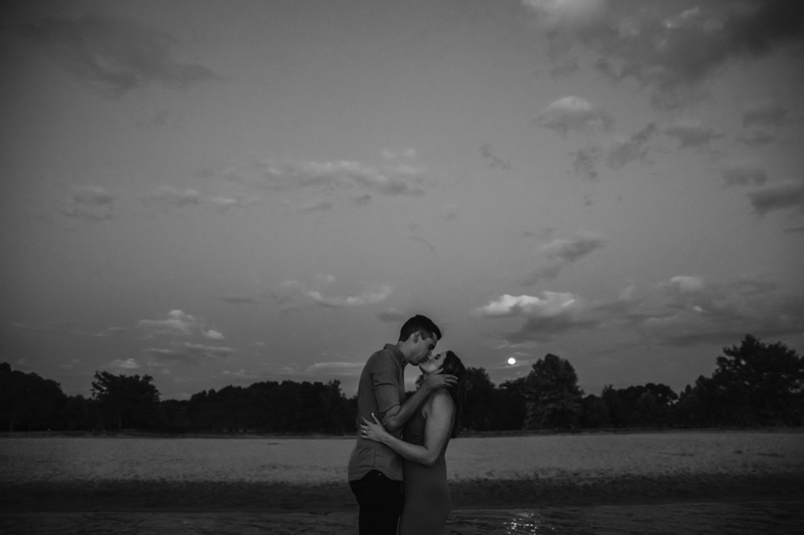 Couple kissing in front of full moon