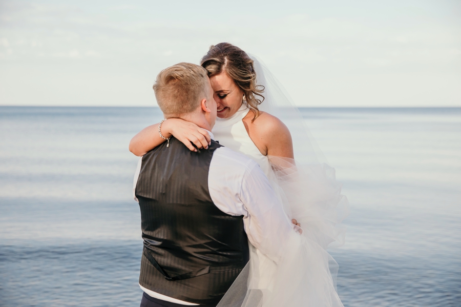 Austin and Amy embracing at sunset, during their Lakeport Michigan Wedding
